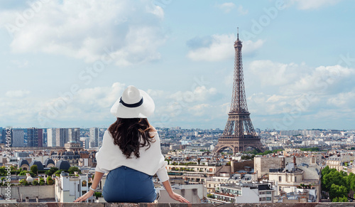 Traveling in Europe, Young woman in white hat looking at Eiffel tower, famous landmark and travel destination in Paris, France in summer
