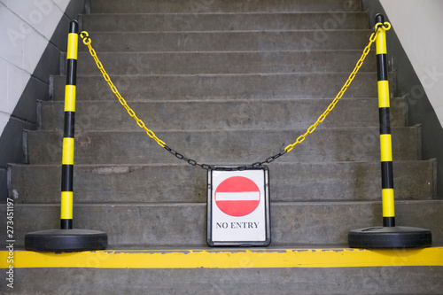 Fotografie No entry sign and yellow chain in front of stair steps