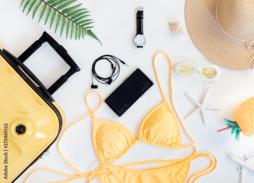 top view travel concept with luggage, bikini, smartphone and Outfit of traveler on white table background, Tourist essentials, vintage tone effect top view travel concept with luggage, bikini, smartphone and Outfit of traveler on white table background, Tourist essentials, vintage tone effect