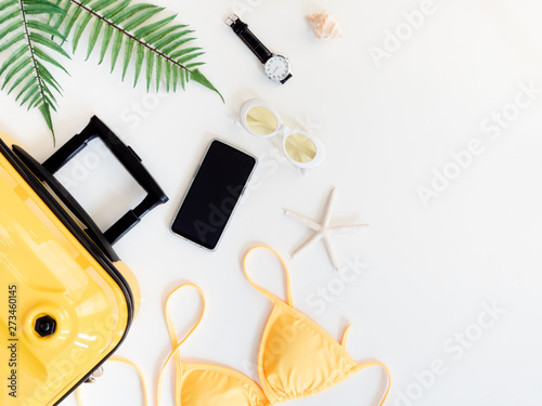 top view travel concept with luggage, bikini, smartphone and Outfit of traveler on white table background, Tourist essentials, vintage tone effect