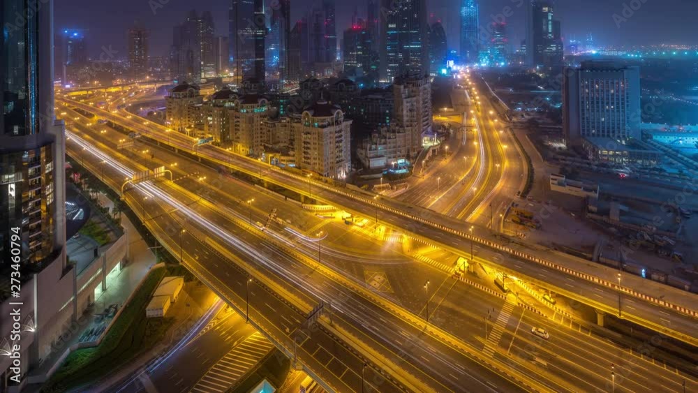 Dubai downtown skyline night to day transition aerial timelapse with traffic on highway, UAE. Top view from rooftop of skyscraper with modern towers near intersection of Al Saada street and Financial Dubai downtown skyline night to day transition aerial timelapse with traffic on highway, UAE. Top view from rooftop of skyscraper with modern towers near intersection of Al Saada street and Financial