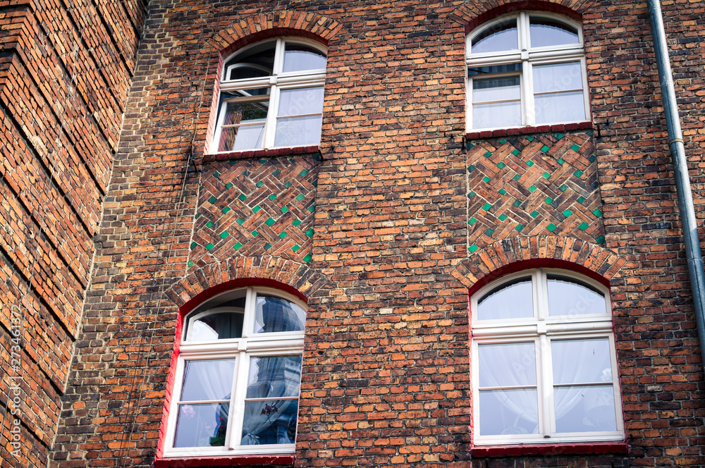 Fototapeta premium Detale architektoniczne, mozaikowy mur z cegieł z oknami, w domach dzielnicy kopalnianej.