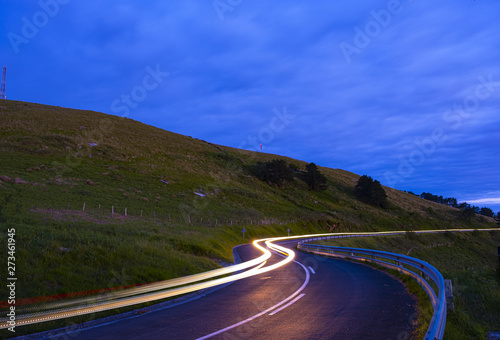 headlights, car driving at speed at night on a mountain road photo