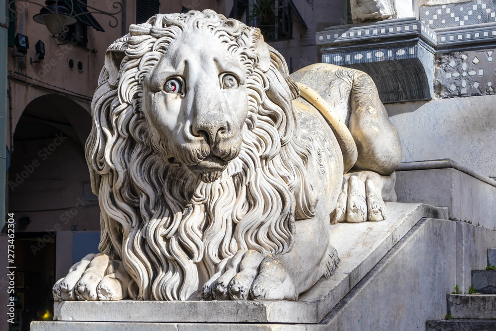 The statue of a sad lion at the entrance of the San Lorenzo Cathedral,Genoa, Italy