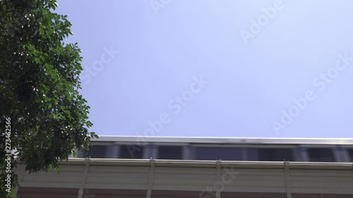 Low angle view as a city passenger train passes left to right on an elevated track system.