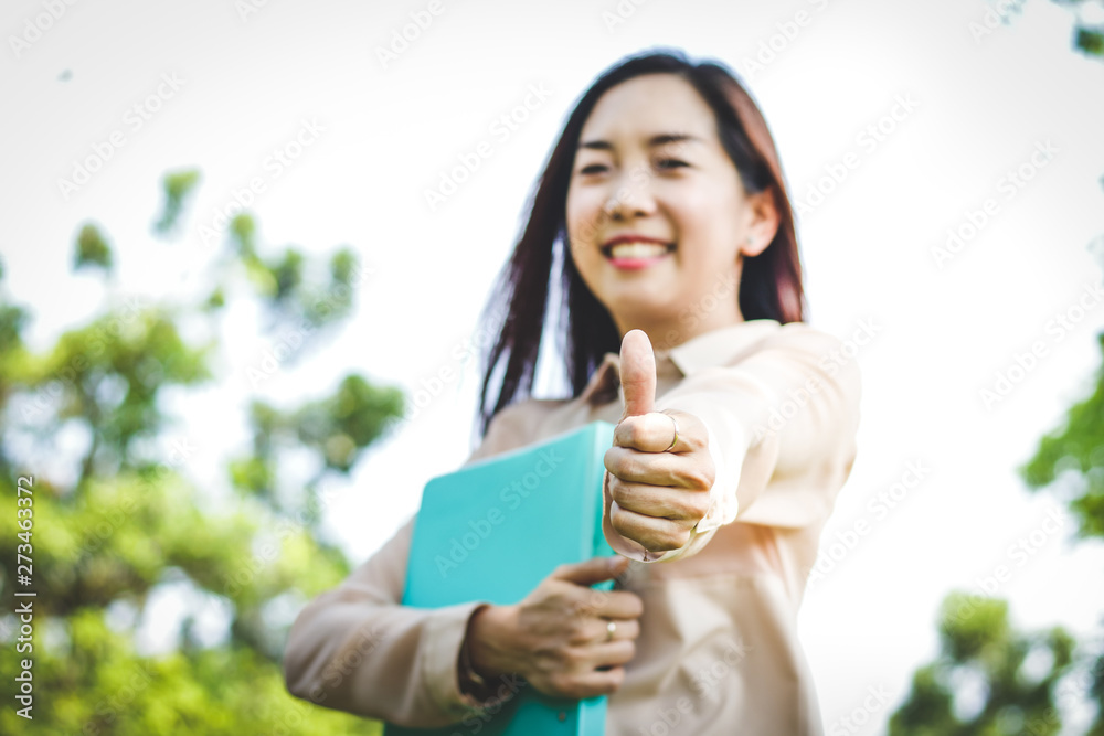 Fototapeta premium Asian girls holding documents, thumbs up