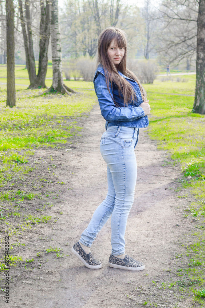 Girl in the spring in the park for a walk. The girl in the park. Walk in the park. in jeans and t-shirt. Girl in the spring in the park for a walk. The girl in the park. Walk in the park. in jeans and t-shirt.