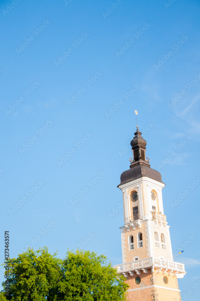 a tall tower with a spire and a dome. Temple. Against the blue sky a tall tower with a spire and a dome. Temple. Against the blue sky