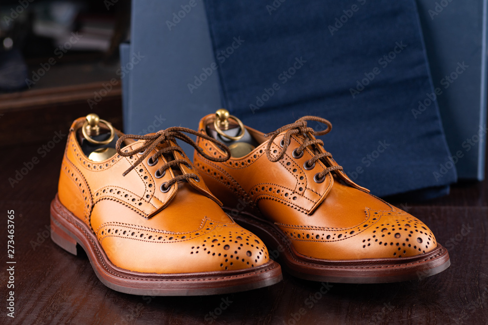 Brown full grain leather brogues on wooden display in in men shoes
