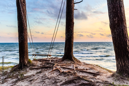 Wooden swing with a nice view to sunset over the baltic sea near Klaipeda, Lithuania. photo