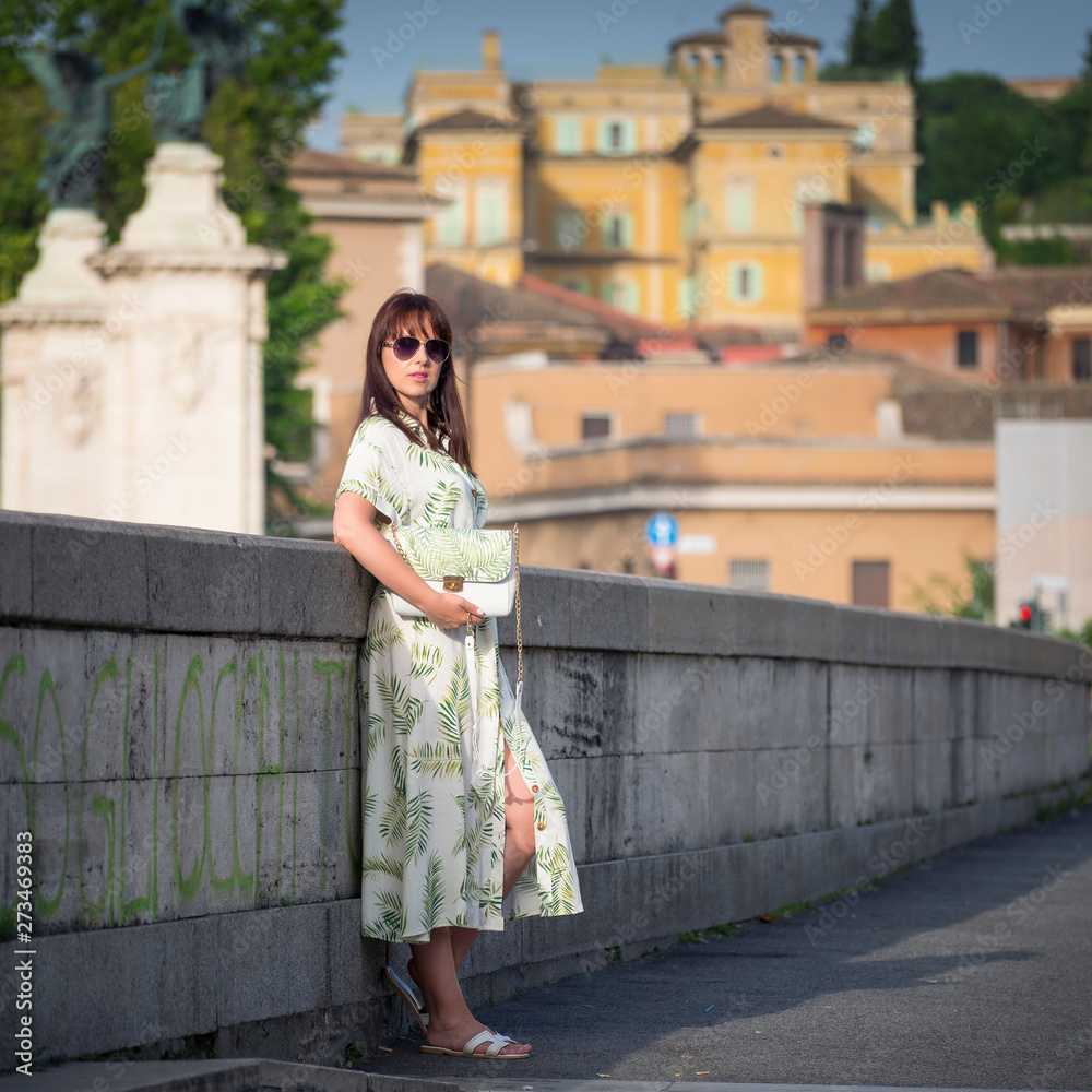 young woman posing on the bridge with city view in summer morning in Rome young woman posing on the bridge with city view in summer morning in Rome