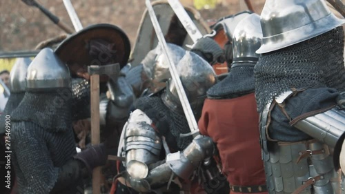 Medieval knight battle. Warriors in full plate armor with melee weapons. Armed men fighting. Real historical warfare reenactment