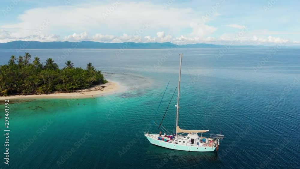 A luxury yacht sails towards a small tropical island in the San Blas Islands. Parallax shot. A luxury yacht sails towards a small tropical island in the San Blas Islands. Parallax shot.