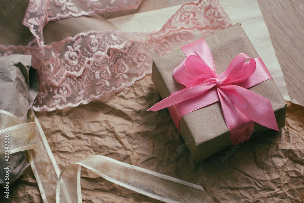 Gift box with satin ribbon. Packaging process. Wedding presents. Craft paper background. Gift box with satin ribbon. Packaging process. Wedding presents. Craft paper background.