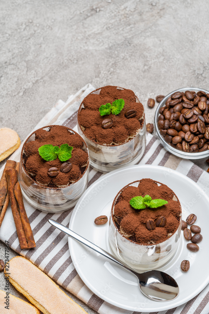 Classic tiramisu dessert in a glass on concrete background Classic tiramisu dessert in a glass on concrete background