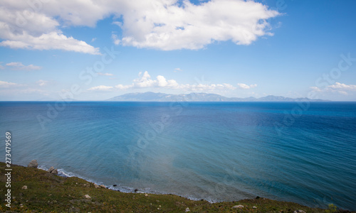 view at blue azure turquoise sea and blue sky and mountains in the horizon and white clouds in Greece Island Kos