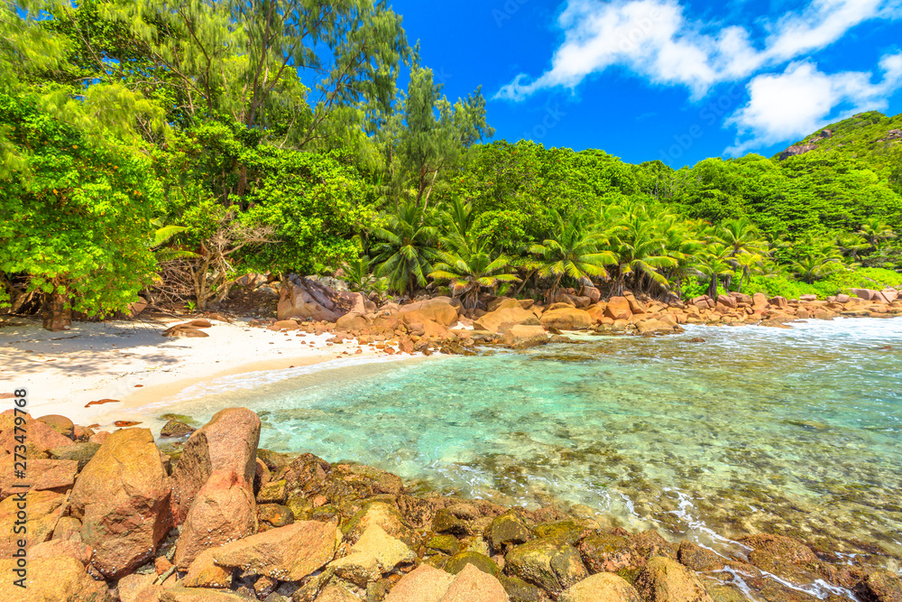 Obraz premium La Digue, Seychelles islands. Remote Anse Caiman with pristine beach between Anse Fourmis and Anse Cocos protected by huge rock formations.Anse Caiman is reached with a trek in the forest