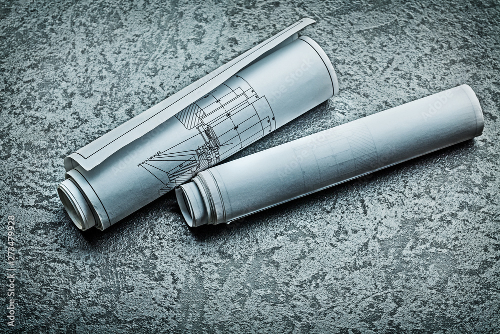 two rooled up blueprints on black background two rooled up blueprints on black background