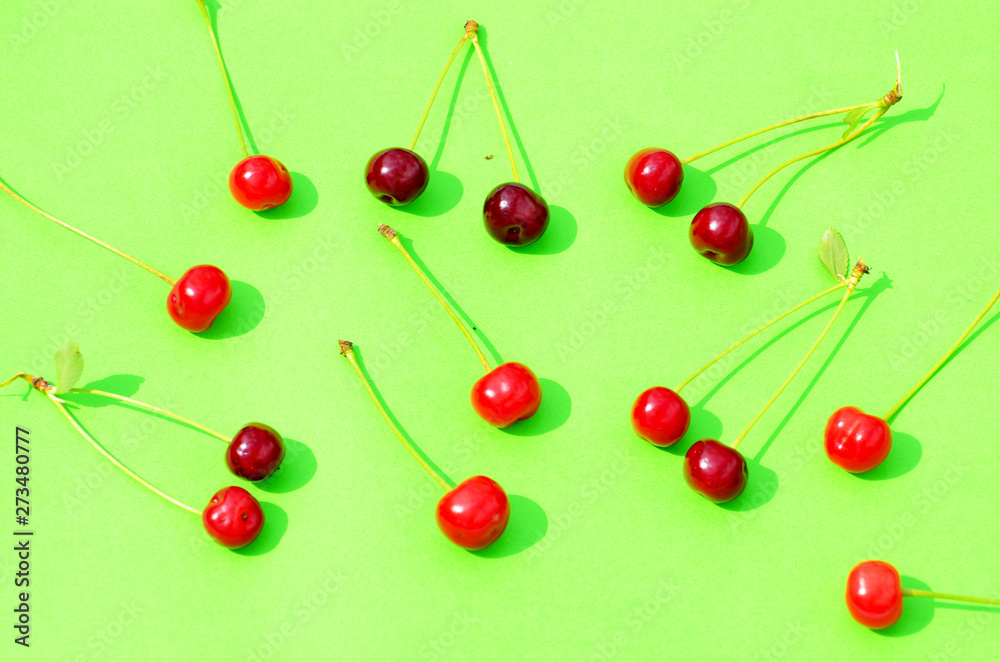 Red cherry isolated on green background, fruit pattern,photo Red cherry isolated on green background, fruit pattern,photo