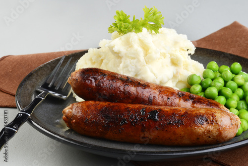 closeup of chorizo sausages with mashed potato and green peas photo