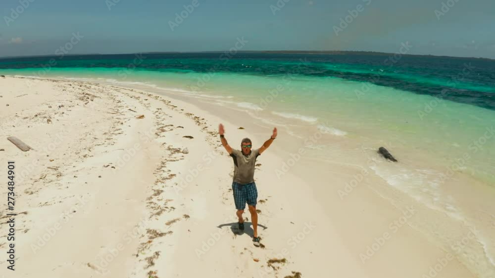 Cheerful man runs along the tropical beach and gets fun and joy on vacation. Cheerful man runs along the tropical beach and gets fun and joy on vacation.