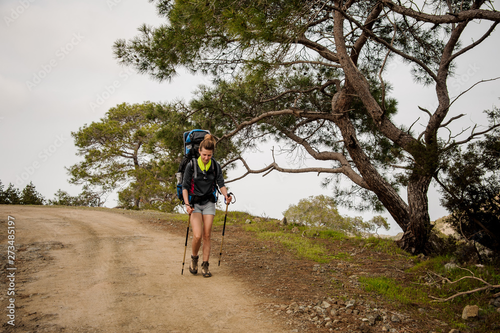 Fototapeta premium Girl walking on the path with hiking backpack