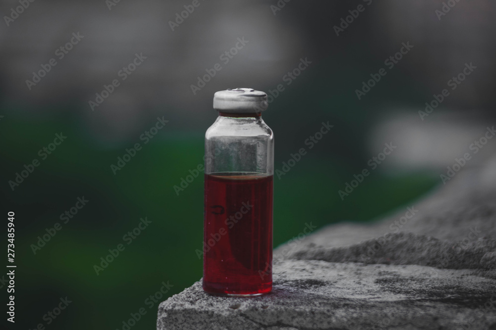 Erlenmeyer flask with red solution standing on a stone surface. Erlenmeyer flask with red solution standing on a stone surface.