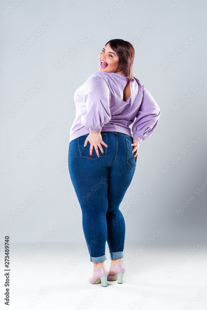 Foto de Happy plus size model in casual clothes, fat woman on gray  background, body positive concept do Stock