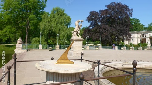 Lazienki Park in city of Warsaw in Poland, pan shot from sundial to the Neoclassical Palace and fountain.