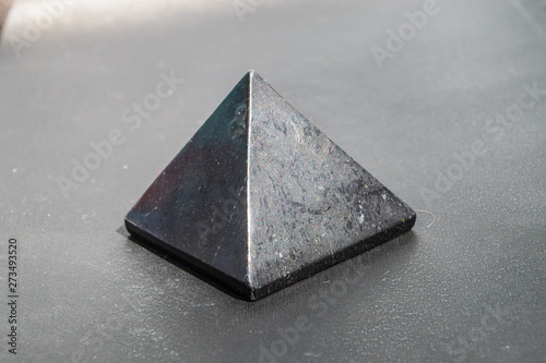 Shungite stone in the shape of a pyramid close up