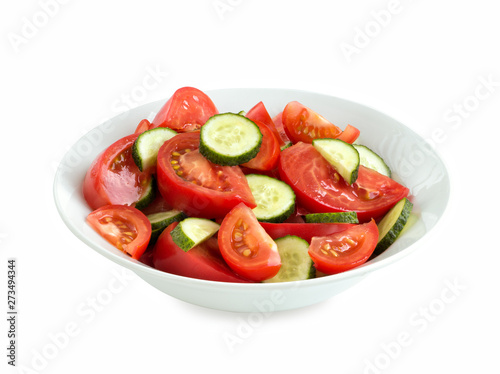 fresh tomato and cucumber salad salad in a white bowl, isolated on white background