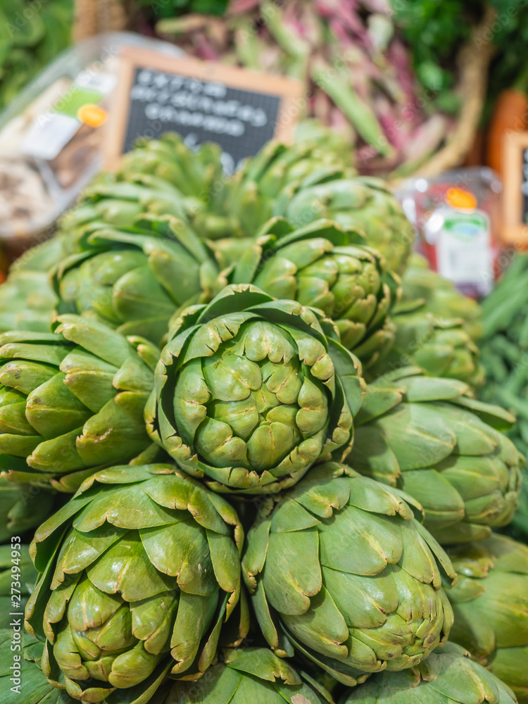set of several well organized artichokes on the shelf of a fruit store set of several well organized artichokes on the shelf of a fruit store