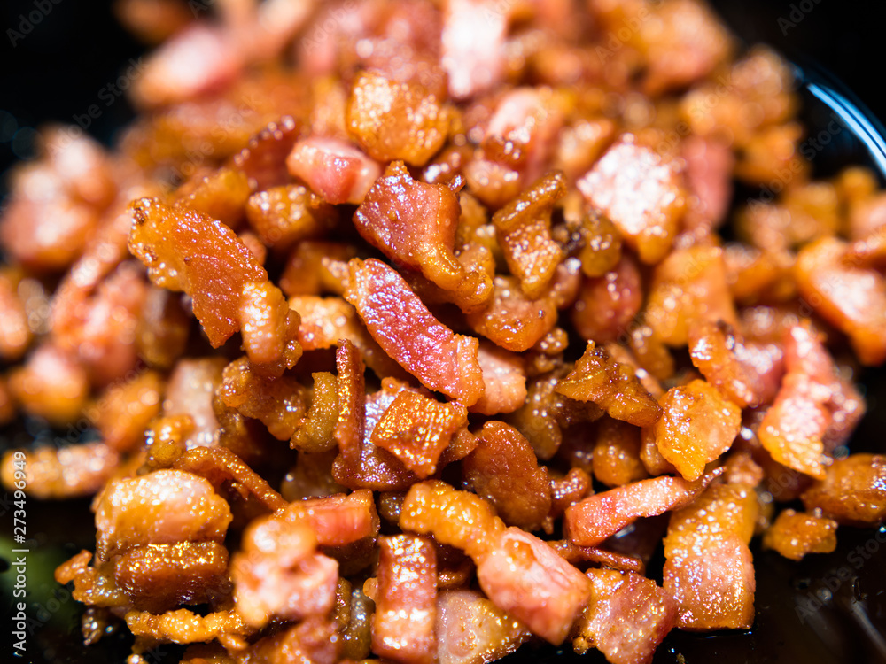 Chopped, crispy fried bacon on black background. Chopped, crispy fried bacon on black background.