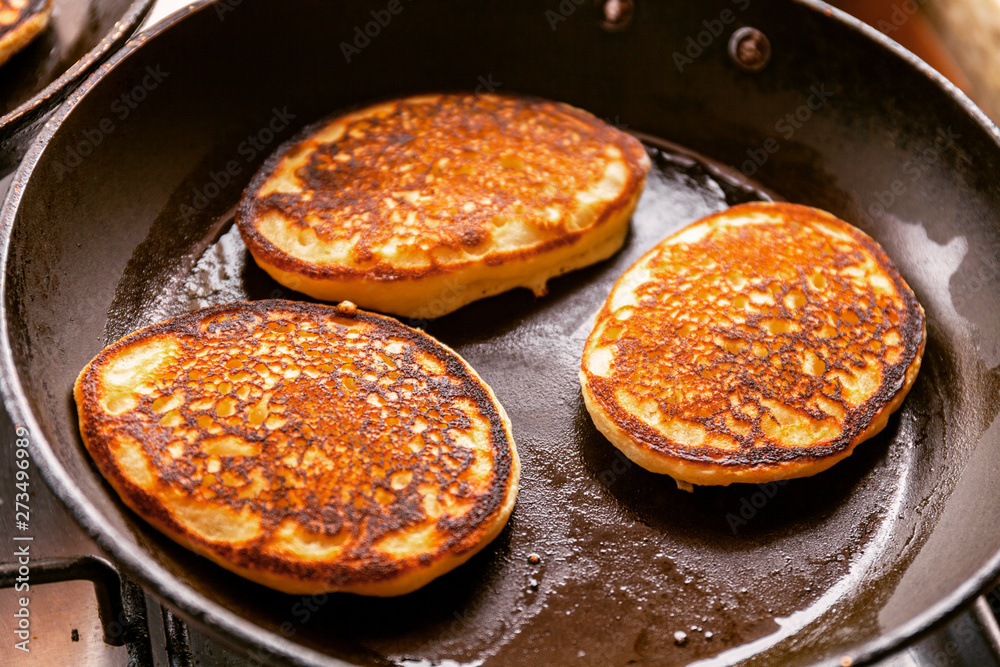 Cooking pancakes in a pan with butter as delicious breakfast meal for a happy family Cooking pancakes in a pan with butter as delicious breakfast meal for a happy family