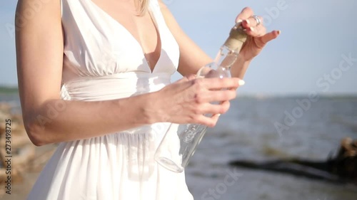 The girl puts her desire in the bottle and lets go into the sea. Bottle on the beach. More videos from this series in my portfolio