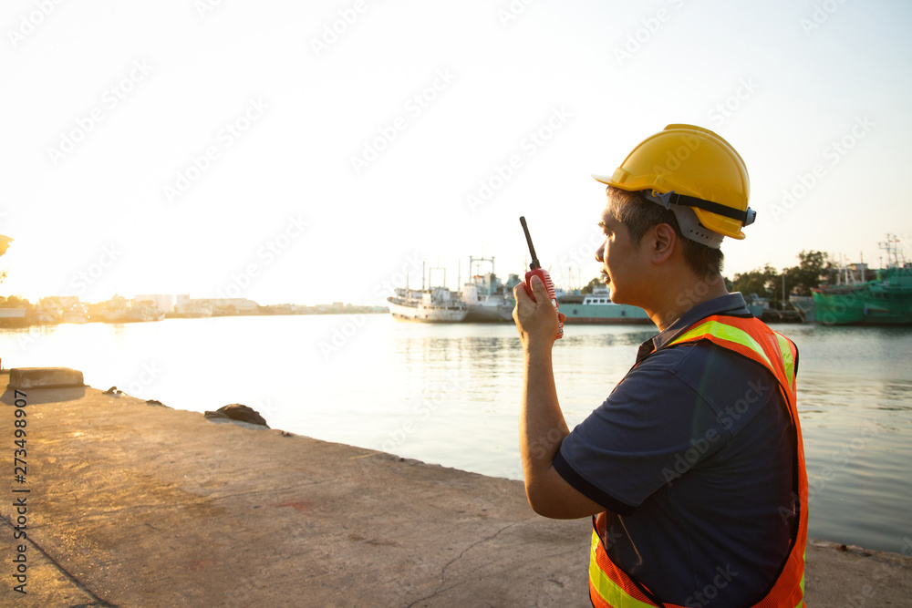 The male engineer holds the radio to order the work to meet the requirements. The male engineer holds the radio to order the work to meet the requirements.
