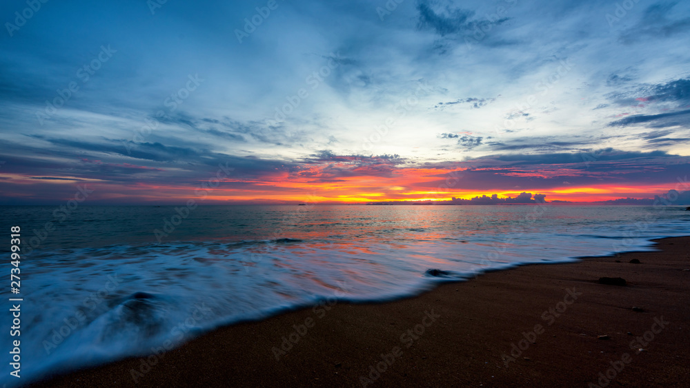 Sand beach with wave bubbles in twilight after the sun sets