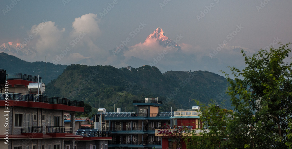 Landscape with Pokhara rooftops on sunrise with Annapurna South, Hiunchuli and Machapuchare Fishtail Peaks in background. Himalaya Mountains, Nepal. Landscape with Pokhara rooftops on sunrise with Annapurna South, Hiunchuli and Machapuchare Fishtail Peaks in background. Himalaya Mountains, Nepal.