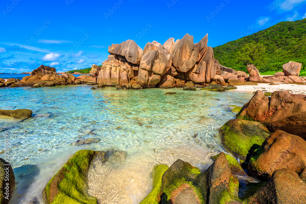 Aerial landscape of natural pool in La Digue, Seychelles Islands. Turquoise calm waters of swimming pools at popular Anse Cocos near Grand Anse and Petite Anse protected by rock formations.