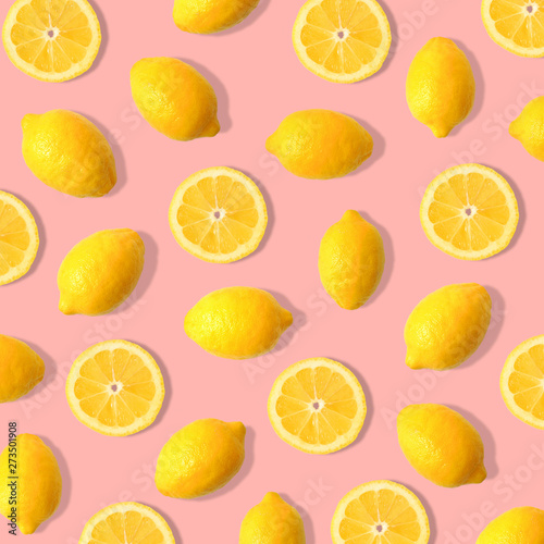 Summer fruit pattern of lemons and lemon slices on a pastel pink background