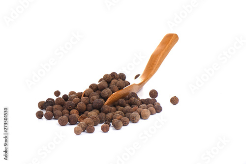 Pepper allspice on culinary wooden scoop isolated on white background. Jamaican bell pepper.