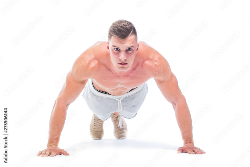 Sports man doing push ups isolated on a white background. Strong Athletic Man - Fitness Model showing his perfect body.