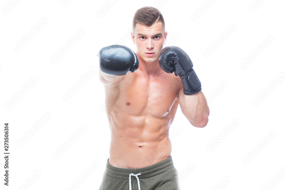 Muscular young man in black boxing gloves and shorts shows the different movements and strikes in the studio on a white background. Strong Athletic Man - Fitness Model showing his perfect body. Copy