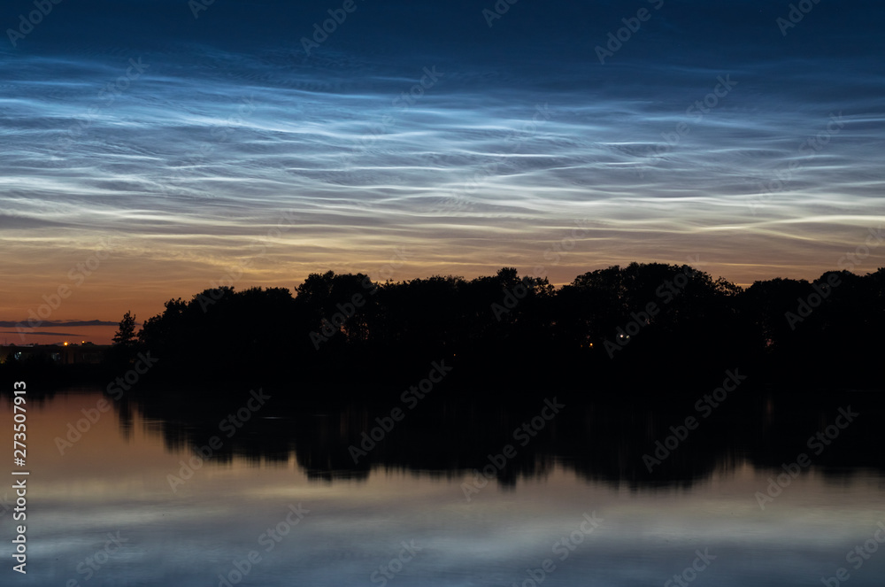 Silvery noctilucent clouds (night shining clouds) landscape over a dutch lake