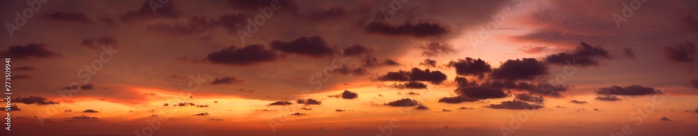 Wide panoramic of pink and orange sunset with dramatic clouds