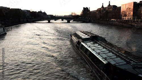 Passenger ships carry tourists across the river at sunset in the evening in Paris,  France 19 March 2019