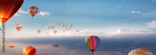 Viele Heißluftballons fliegen  über den Wolken