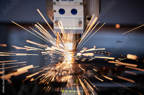 Laser cutting. Metal machining with sparks on CNC laser engraving maching