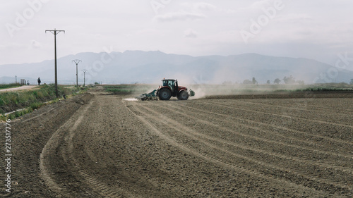 tractor plowing a dusty field