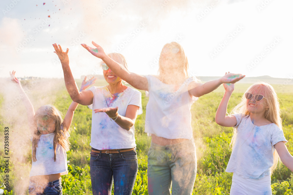 Fototapeta premium Fun, colors, Indian holidays and people concept - young female people having fun on the festival of holi